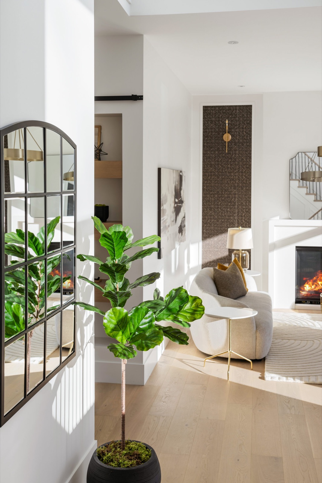 Styled entry hall opening to a living room with fireplace